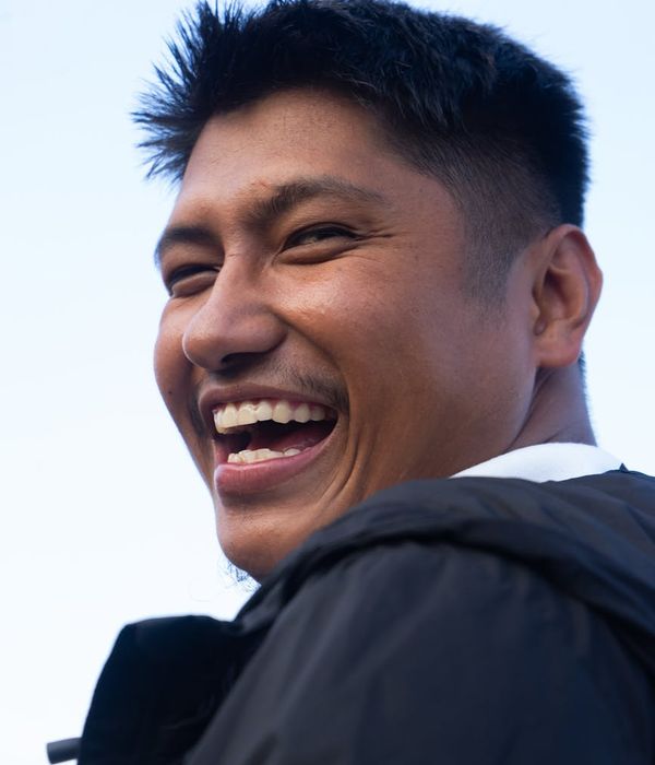 Person smiling peacefully outdoors, feeling refreshed and energetic after a light workout.